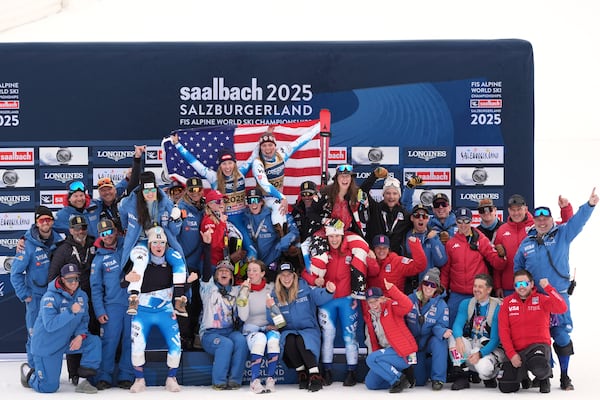 United States' Mikaela Shiffrin, top left, and United States' Breezy Johnson, top right, celebrate with the team after winning the gold medal in a women's team combined event, at the Alpine Ski World Championships, in Saalbach-Hinterglemm, Austria, Tuesday, Feb. 11, 2025. (AP Photo/Giovanni Auletta)