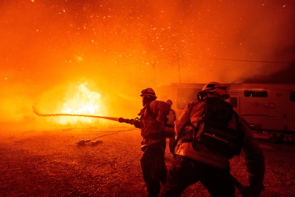 Firefighters spray water on the Hughes Fire in Castaic, Calf., Wednesday, Jan. 22, 2025. (AP Photo/Ethan Swope)