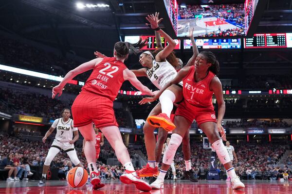 Indiana Fever guard Caitlin Clark, left, battles for the ball with Chicago Sky forward Angel Reese, center, during the second half an WNBA basketball game in Indianapolis, Saturday, May 17, 2025. (AP Photo/AJ Mast)
