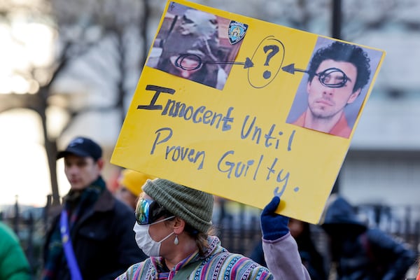 A demonstrator holds up a sign while waiting for the arrival of Luigi Mangione for his arraignment at Manhattan Criminal Court, Monday, Dec. 23, 2024, in New York. (AP Photo/Stefan Jeremiah)