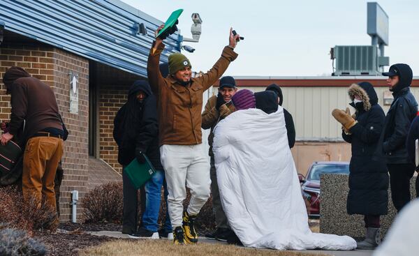 FILE - A man waves to cheering supporters after coming out of the U.S. Immigration and Customs Enforcement office following his immigration check-in in Cedar Rapids, Iowa, Feb. 4, 2025. (Jim Slosiarek/The Gazette Via AP, File)