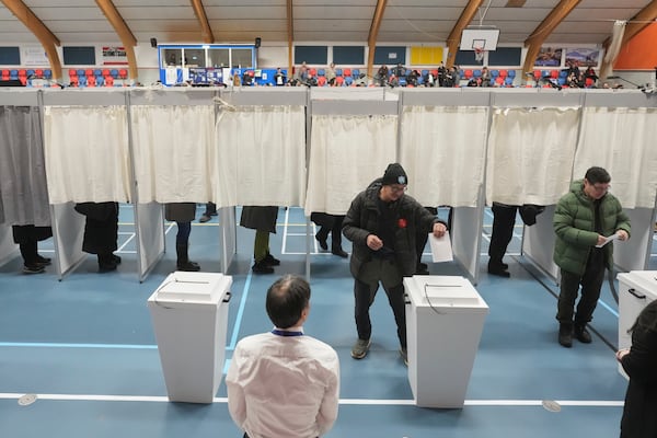 People stand in booths and cast their vote at a polling station during parliamentary elections, in Nuuk, Greenland, Tuesday, March 11, 2025. (AP Photo/Evgeniy Maloletka)