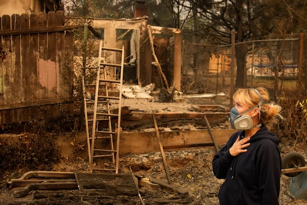 Lissa Renn looks at remains of her neighborhood In Altadena, Calif., Thursday, Jan. 9, 2025. (AP Photo/John Locher)