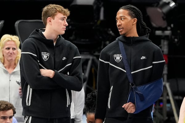 Duke forward Cooper Flagg, left, and forward Maliq Brown watch warms ups before an NCAA college basketball game against North Carolina in the semifinals of the Atlantic Coast Conference tournament, Friday, March 14, 2025, in Charlotte, N.C. Flagg and Brown were injured yesterday. (AP Photo/Chris Carlson)