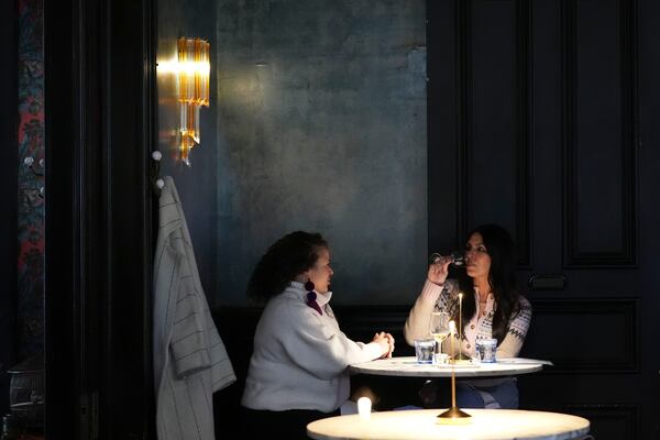 Patrons converse and drink in the bar of Columns Hotel on St. Charles Ave., in New Orleans, Friday, Jan. 24, 2025. (AP Photo/Gerald Herbert)