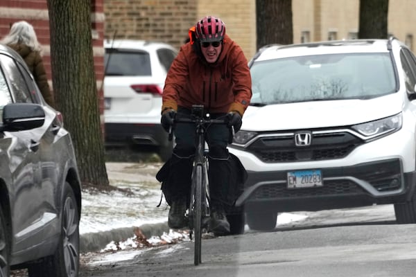 A man rides a bicycle during cold weather in Chicago, Wednesday, Jan. 8, 2025. (AP Photo/Nam Y. Huh)