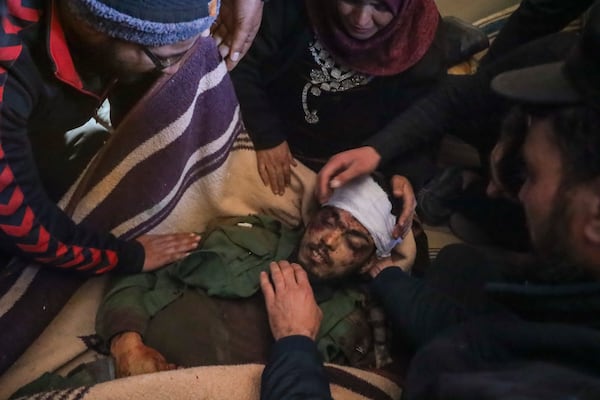 EDS NOTE: GRAPHIC CONTENT.- Relatives mourn over the body of Syrian government fighter Ahmed Al-Shaghri, who was killed in clashes with loyalists of ousted President Bashar Assad in coastal Syria, during his funeral in the village of Al-Janoudiya, west of Idlib, Saturday, March 8, 2025. (AP Photo/Omar Albam)