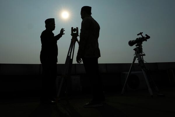 FILE - Officials are silhouetted as they use a telescope to scan the horizon for a crescent moon that will determine the beginning of the holy fasting month of Ramadan in Jakarta, Indonesia, Wednesday, March. 22, 2023. (AP Photo/Achmad Ibrahim, File)