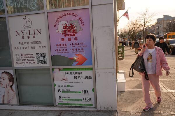 Signs in Chinese and English are displayed the Brooklyn borough of New York, Friday, Feb. 28, 2025. (AP Photo/Seth Wenig)