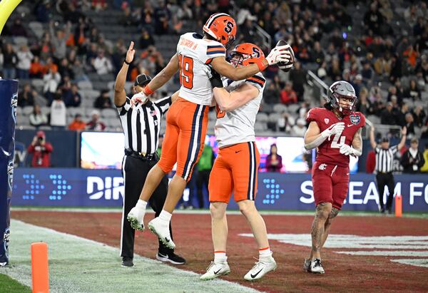 Syracuse tight end Oronde Gadsden II (19) is congratulated by tight end Maximilian Mang (0) after scoring a touchdown during the first half of the Holiday Bowl NCAA college football game against Washington State Friday, Dec. 27, 2024, in San Diego. (AP Photo/Denis Poroy)