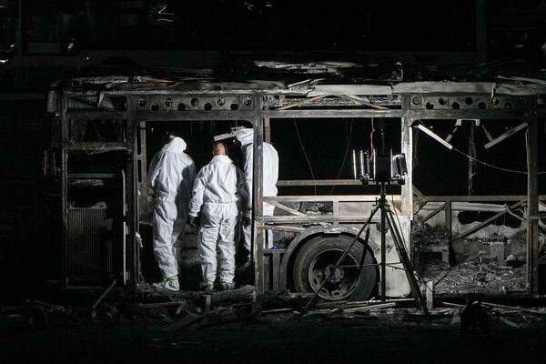 Israeli police inspect the scene of one of a series of bus explosions in what authorities said appeared to be a militant attack in Bat Yam, central Israel, Thursday, Feb. 20, 2025. (AP Photo/Ohad Zwigenberg)