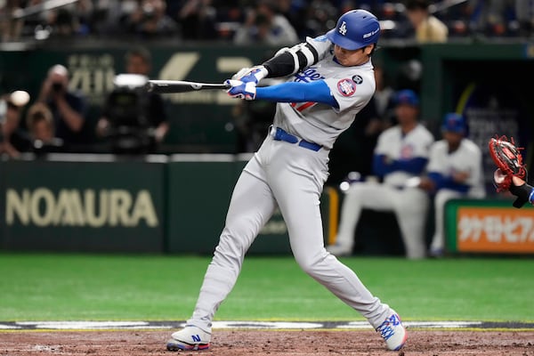 Los Angeles Dodgers' Shohei Ohtan follows connects for a single in the fifth inning of an MLB Japan Series baseball game against the Chicago Cubs in Tokyo, Japan, Tuesday, March 18, 2025. (AP Photo/Eugene Hoshiko)