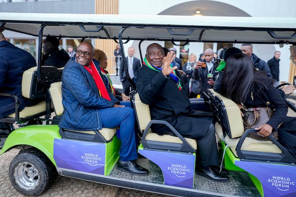 Cyril Ramaphosa, President of South Africa, right uses a shuttle the Annual Meeting of World Economic Forum in Davos, Switzerland, Wednesday, Jan. 22, 2025. (AP Photo/Markus Schreiber)