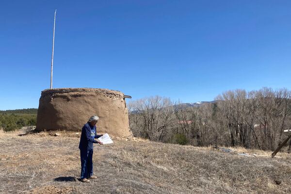 In this photo provided by researchers, Clifford Tsosie stands in front of the Round House in Picuris Pueblo, N.M., in April 2024. It is one of the Picuris' ritual rooms, used by members of the summer and winter society for rituals and meetings. (Thomaz Pinotti via AP)