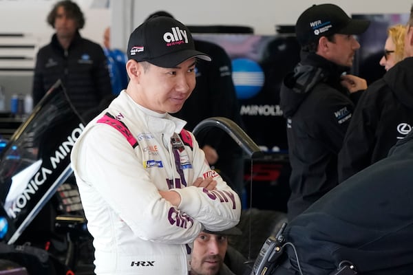 FILE - Kamui Kobayashi, of Japan, watches crew members work on his car in the garage during practice for the Rolex 24 hour auto race at Daytona International Speedway, Jan. 27, 2022, in Daytona Beach, Fla. (AP Photo/John Raoux, File)