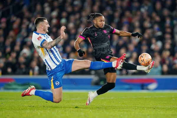 Brighton and Hove Albion's Lewis Dunk, left, and Chelsea's Christopher Nkunku battle for the ball during the English FA Cup fourth round soccer match between Brighton & Hove Albion and Chelsea at American Express Stadium, Brighton, England, Saturday Feb. 8, 2025. (Gareth Fuller/PA via AP)