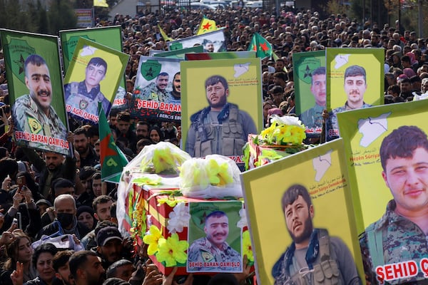 The coffins of two of six Kurdish fighters from the Syrian Democratic Forces (SDF) killed in ongoing clashes with Turkish-backed militias in northern Syria are carried during their funeral in Qamishli, northeastern Syria, Thursday, Dec. 26, 2024. (AP Photo/Hogir El Abdo)