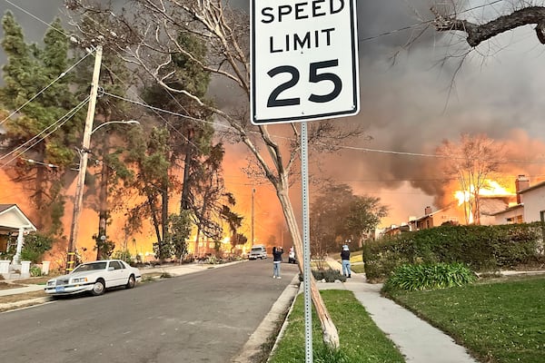 The Eaton Fire burns homes as Ryan Pearson, a Los Angeles-based entertainment video editor for The Associated Press, drives through his neighborhood in Altadena, Calif., Wednesday, Jan. 8, 2025. (AP Photo/Ryan Pearson)