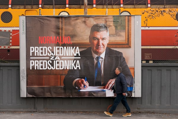 A pedestrian walks past a campaign poster of President incumbent Zoran Milanovic, days ahead of the run-off of the Croatian presidential election, in Zagreb, Croatia, Tuesday, Jan. 7, 2025. (AP Photo/Darko Bandic)