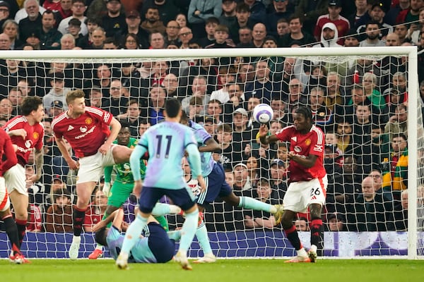 Manchester United's Ayden Heaven, right, clears the ball during the English Premier League soccer match between Manchester United and Arsenal at Old Trafford stadium in Manchester, England, Sunday, March 9, 2025. (AP Photo/Dave Thompson)