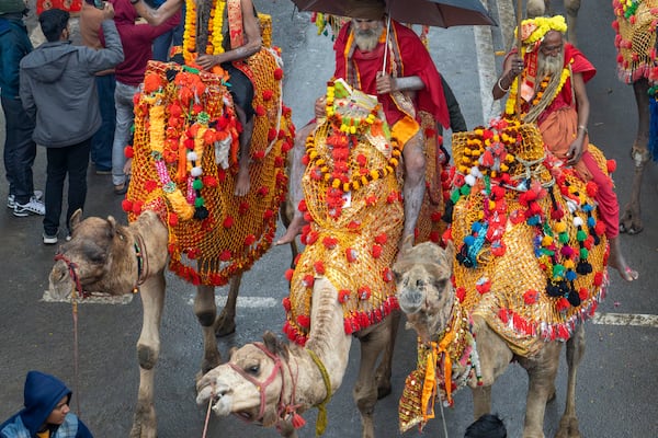 Hindu holy men ride camels during a procession, a day before the 45-day-long Maha Kumbh festival, in Prayagraj, India, Sunday, Jan. 12, 2025. (AP Photo/Ashwini Bhatia)