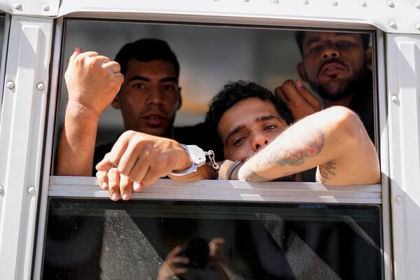 Colombian migrants look out from a Panamanian immigration bus transporting them from a migrant reception center in Lajas Blancas, where they arrived after crossing the Darien Gap en route to the U.S. southern border, to a police station in Panama City, March 11, 2025. (AP Photo/Matias Delacroix)
