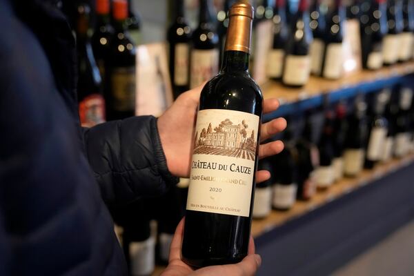 Carlos Olivares holds a bottle of Château du Cauze, Saint-Emilion Grand Cru, a French Bordeaux wine, before purchasing it at DECANTsf Bottle Shop and Bar in San Francisco, Thursday, March 13, 2025. (AP Photo/Jeff Chiu)