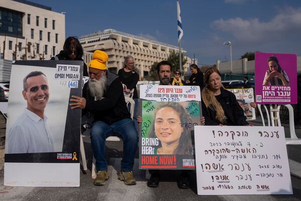 Families and supporters of Israeli hostages held by Hamas in Gaza, hold photos of their loved ones during a protest calling for their release outside the prime minister's office in Jerusalem, Sunday, Jan. 26, 2025. (AP Photo/Ohad Zwigenberg)