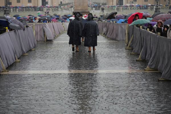 Participants in a mass for the jubilar pilgrims from Naples wait for the start of the celebration under pouring rain in St. Peter's Square at The Vatican, Saturday, March 22, 2025. (AP Photo/Andrew Medichini)