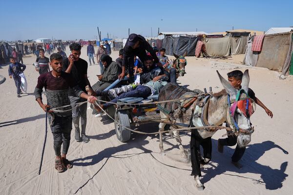 Palestinians carry an injured man after he was shot at an aid distribution center run by the Gaza Humanitarian Foundation a U.S.-backed organization approved by Israel in Khan Younis, southern Gaza Strip, on Thursday, May 29, 2025. (AP Photo/Abdel Kareem Hana)