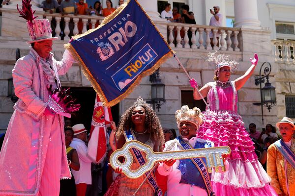 Carnival King Momo, Kaio Mackenzie, front right, and Queen Thuane de Oliveira, hold the keys of the city at a ceremony that officially kicks off Carnival in Rio de Janeiro, Brazil, Friday, Feb. 28, 2025. (AP Photo/Silvia Izquierdo)