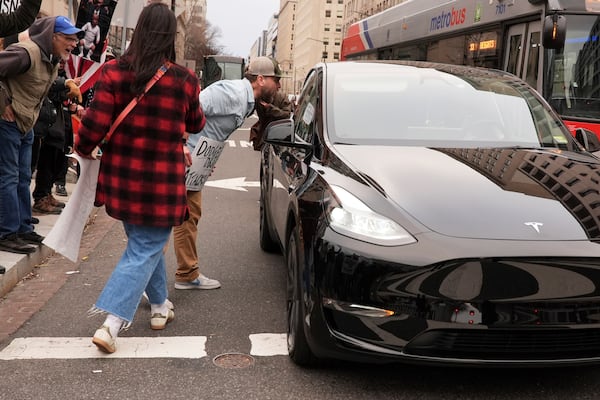 Demonstrators shout at a driver of a Tesla as they protest against the Trump administration near the White House Friday, March 14, 2025, in Washington. (AP Photo/Jacquelyn Martin)