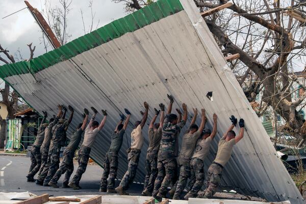 This photo provided by the French Army shows soldiers lifting a collapsed barrier in the Indian Ocean French territory of Mayotte, Wednesday Dec.18, 2024, as the cyclone on Saturday was the deadliest storm to strike the territory in nearly a century. (D Piatacrrea, Etat Major des Armees/Legion Etrangere via AP)