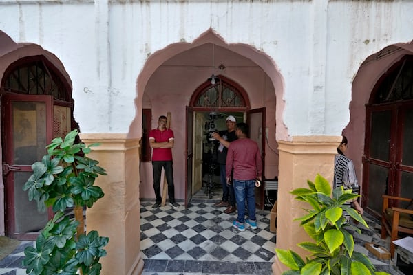 A cameraman and technicians prepare themselves for next shot during the shooting of a scene of tv drama serial ''Tan Man Neel-o-Neel' or Deeply Engrossed in Love',, in Rawalpindi, Pakistan, Saturday, Nov. 2, 2024. (AP Photo/Anjum Naveed)