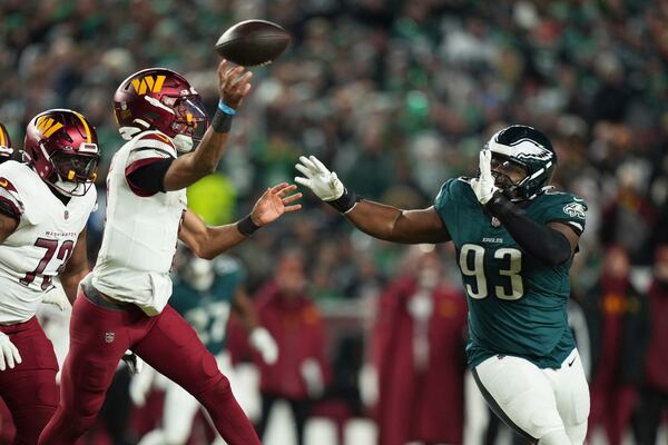 Washington Commanders quarterback Jayden Daniels, left, is pressured by Philadelphia Eagles defensive tackle Milton Williams (93) during the second half of the NFC Championship NFL football game, Sunday, Jan. 26, 2025, in Philadelphia. (AP Photo/Matt Slocum)