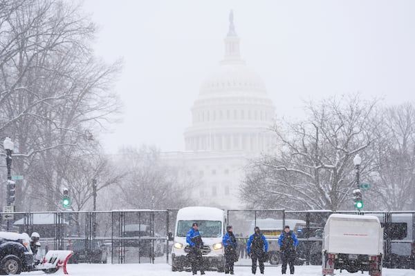 Law enforcement officers stand guard at the Capitol as snow falls ahead of a joint session of Congress to certify the votes from the Electoral College in the presidential election, in Washington, Monday, Jan. 6, 2025. (AP Photo/Matt Rourke)