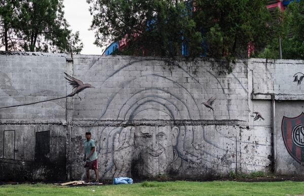 A man stands in front of a mural of Pope Francis outside the stadium of San Lorenzo, his soccer team, in the Padre Ricciardelli neighborhood of Buenos Aires, Argentina, Tuesday, Feb. 25, 2025. (AP Photo/Rodrigo Abd)