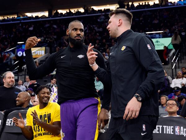 Los Angeles Lakers forward LeBron James, left, and guard Luka Doncic talk during an NBA basketball game against the Los Angeles Clippers, Tuesday, Feb. 4, 2025, in Inglewood, Calif. (AP Photo/Kevork Djansezian)