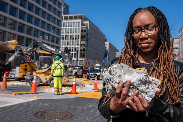 Tears roll down the face of Starlette Thomas, of Bowie, Md., as she holds a chunk of pavement from the Black Lives Matter mural, Monday, March 10, 2025, as the mural begins to be demolished in Washington. "I needed to be here to bear witness," says Thomas, who was present at the 2020 George Floyd protests. "For me the Black Lives Matter sign etched in stone was a declaration of somebodyness and to watch it be undone in this way was very hurtful. To walk away with a piece of that, it means it's not gone. It's more than brick and mortar." (AP Photo/Jacquelyn Martin)