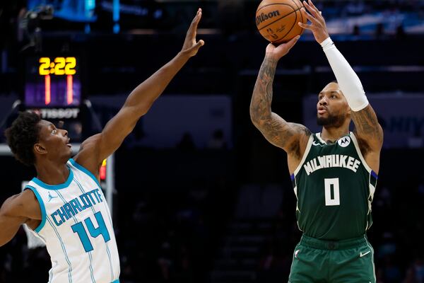 Milwaukee Bucks guard Damian Lillard (0) shoots over Charlotte Hornets forward Moussa Diabate during the second half of an NBA basketball game in Charlotte, N.C., Wednesday, Feb. 5, 2025. (AP Photo/Nell Redmond)