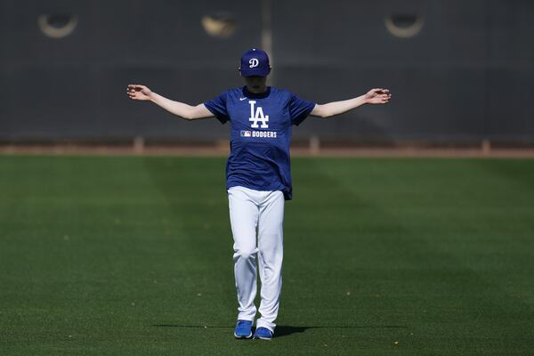 Los Angeles Dodgers pitcher Roki Sasaki, of Japan, stretches out at the Dodgers baseball spring training facility, Tuesday, Feb. 11, 2025, in Phoenix. (AP Photo/Ross D. Franklin)