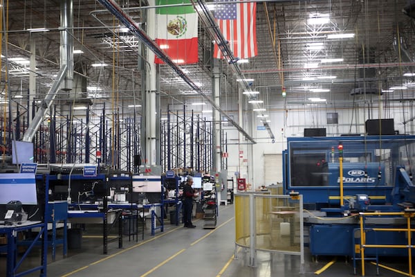 National flags representing the United States and Mexico hang inside in a textile factory that produces T-shirts, in Ciudad Juarez, Mexico, Tuesday, Feb. 4, 2025. (AP Photo/Christian Chavez)