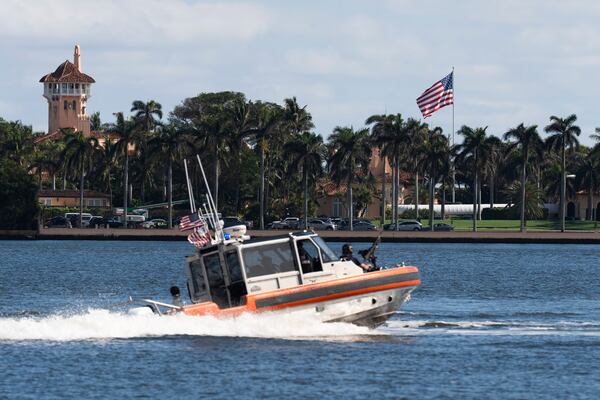 The U.S. flag is shown at the Mar-a-Lago compound in Palm Beach, Fla., while a U.S. Coast Guard boat patrols around the vicinity, Monday, Jan. 13, 2025. U.S. flags at President-elect Donald Trump's private Mar-a-Lago club are back to flying at full height. Flags are supposed to fly at half-staff through the end of January out of respect for former President Jimmy Carter, who died Dec. 29. (AP Photo/Manuel Balce Ceneta)