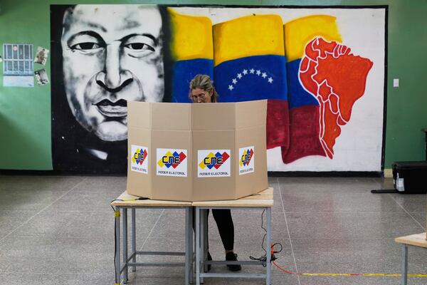 A voter marks her ballot and candidate in legislative and local elections in Caracas, Venezuela, Sunday, May 25, 2025. (AP Photo/Ariana Cubillos)