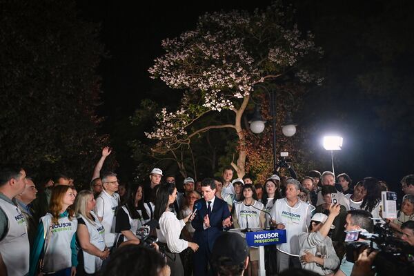 Presidential candidate Nicusor Dan speaks to media, surrounded by supporters, after polls closed in the first round of the country's presidential election redo in Bucharest, Romania, Sunday, May 4, 2025. (AP Photo/Eduard Vinatoru)