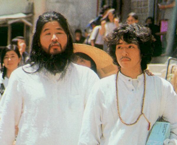 FILE - In this undated file photo, cult guru Shoko Asahara, left, of Aum Shinrikyo walks with Yoshihiro Inoue, then a close aid, in Tokyo. (Kyodo News via AP, File)