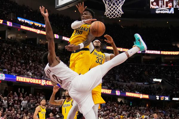 Cleveland Cavaliers forward De'Andre Hunter (12) falls after Indiana Pacers guard Bennedict Mathurin (00) blocked his shot in the second half during Game 1 in the Eastern Conference semifinals of the NBA basketball playoffs Sunday, May 4, 2025, in Cleveland. (AP Photo/Sue Ogrocki)