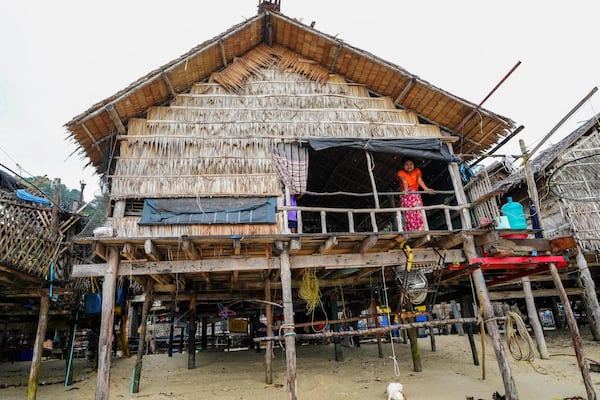 Kiroom Klathale stands on her house at Surin Islands in Phang Nga Province, Thailand, Thursday, Dec. 12, 2024. (AP Photo/Sakchai Lalit)