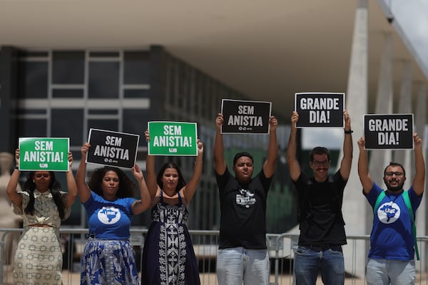 Demonstrators hold signs that read in Portuguese "No amnesty" outside the Supreme Court where the trial of Brazil's former President Jair Bolsonaro takes place in Brasilia, Brazil, Tuesday, March 25, 2025. (AP Photo/Eraldo Peres)