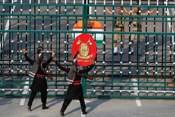 Pakistan's Rangers soldiers, in black, and Indian Border Security Forces soldiers, behind gate, gesture each others during a daily closing ceremony at the Wagah, a joint post on the Pakistan and India border, near Lahore, Pakistan, Monday, May 5, 2025. (AP Photo/K.M. Chaudary)